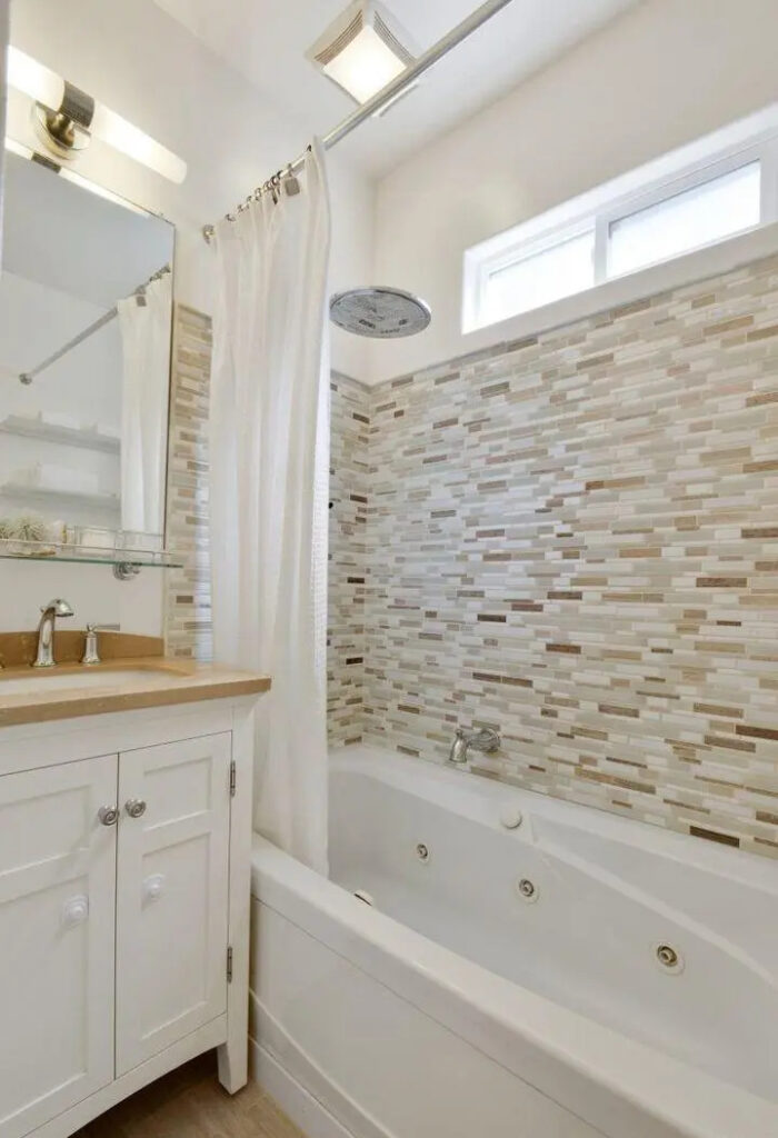 Contemporary bathroom remodel with mosaic tile shower surround, white vanity, and spa tub in a Lower Haight Edwardian condo.