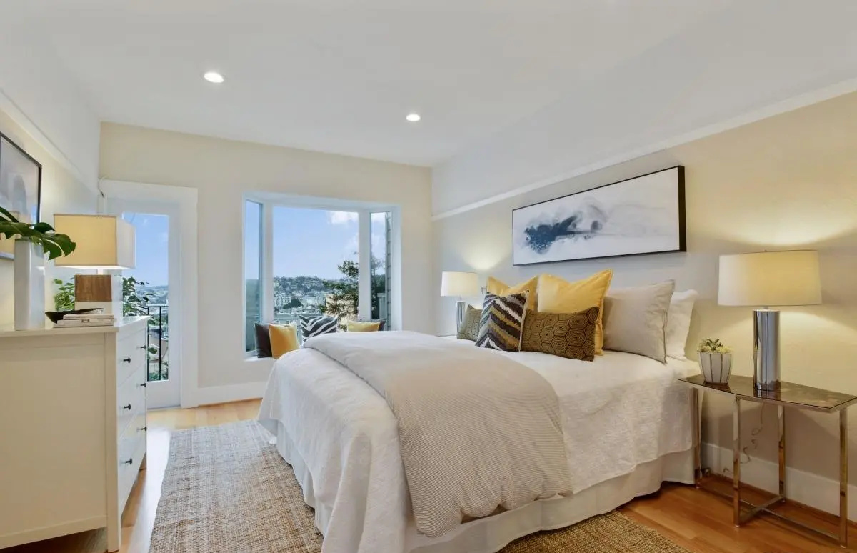 Primary bedroom with panoramic city views, large bay window, and natural light in a San Francisco Lower Haight condo renovation.