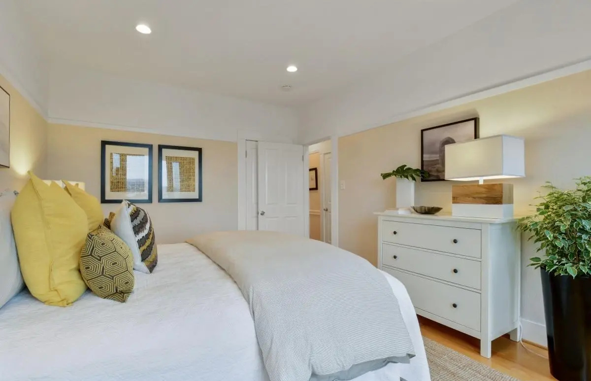 Bright primary bedroom featuring soft modern decor, recessed lighting, and minimalist furniture in a Lower Haight condo remodel.
