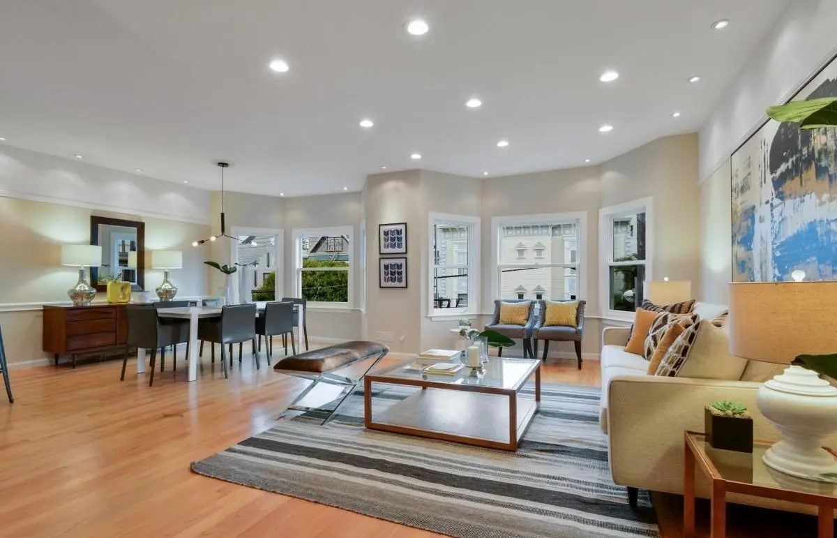 Light-filled living and dining area showcasing bay windows and modern interior design in a Lower Haight condo remodel.
