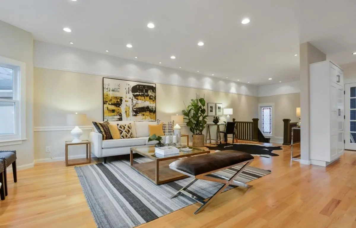 Modern living room and hallway design with warm tones and recessed lighting in a Lower Haight Edwardian renovation.