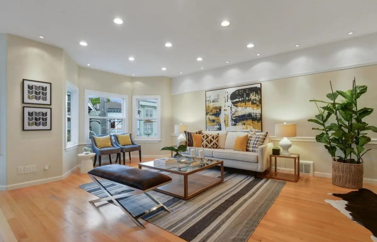 Edwardian-style living room with large windows, layered lighting, and contemporary furnishings in Lower Haight, San Francisco.