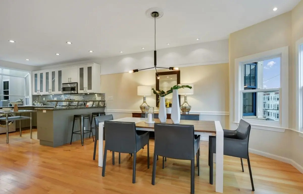 Dining area and kitchen integration with modern lighting and open layout in a Lower Haight condo renovation.