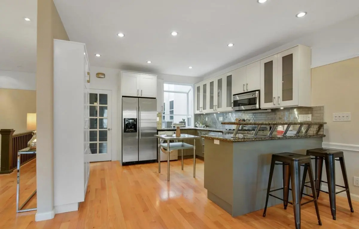 Bright modern kitchen with breakfast bar, subway tile backsplash, and stainless appliances in a Lower Haight Edwardian renovation.