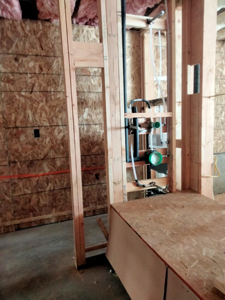 Hansgrohe iBox tub valve PEX rough-in installation with insulation and precise framing in San Francisco bathroom.