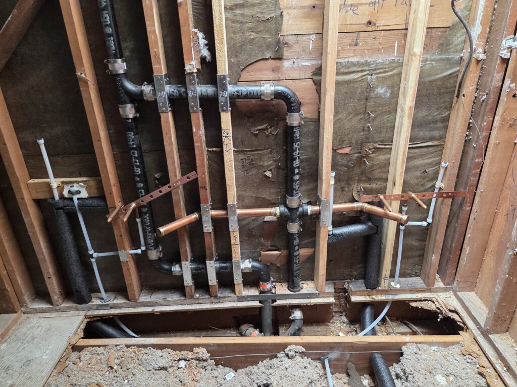 Double lavatory top-out with cast iron DWV and PEX supply tied into existing vent stack.