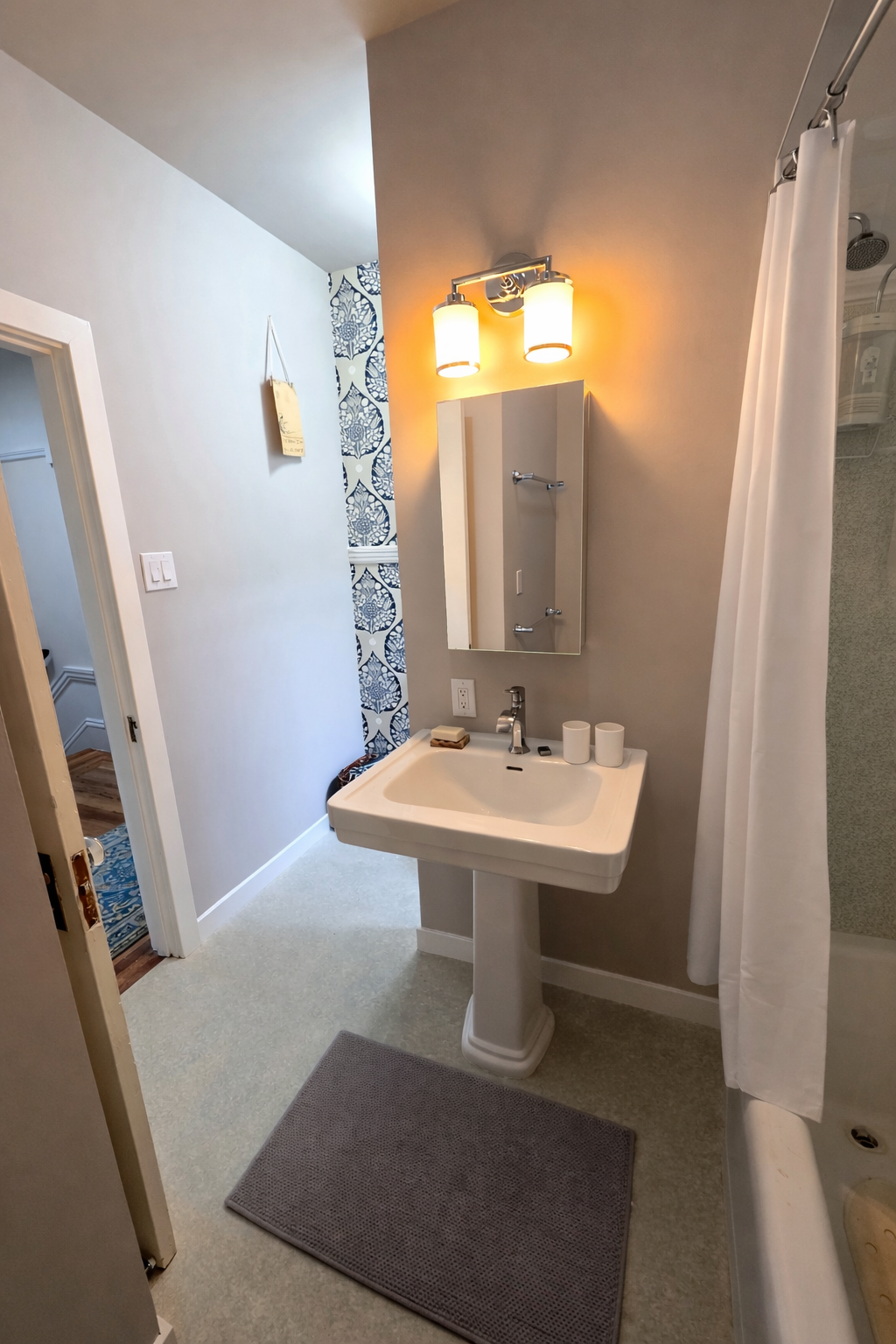 Updated vanity area with pedestal sink, medicine cabinet, and modern lighting after bathroom renovation in Richmond District San Francisco